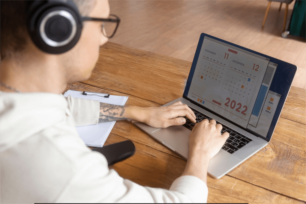 Person working on laptop with headphones